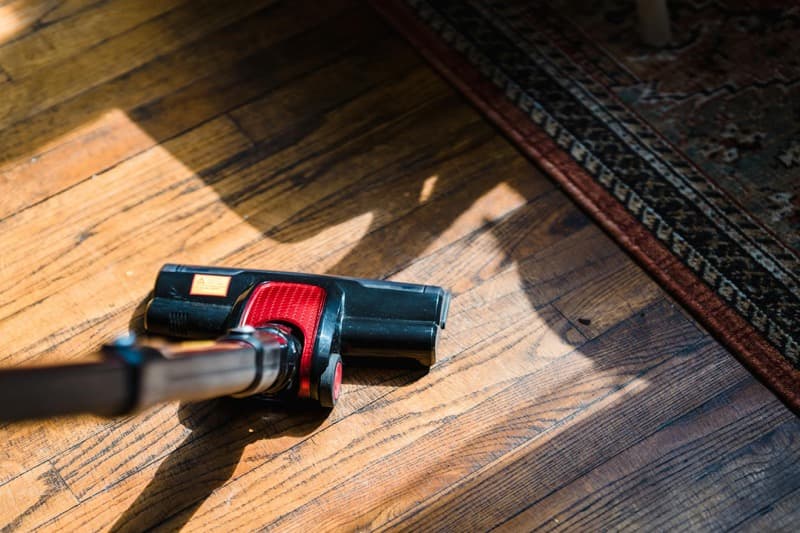 hardwood floor being refinished with drum sander showing before and after